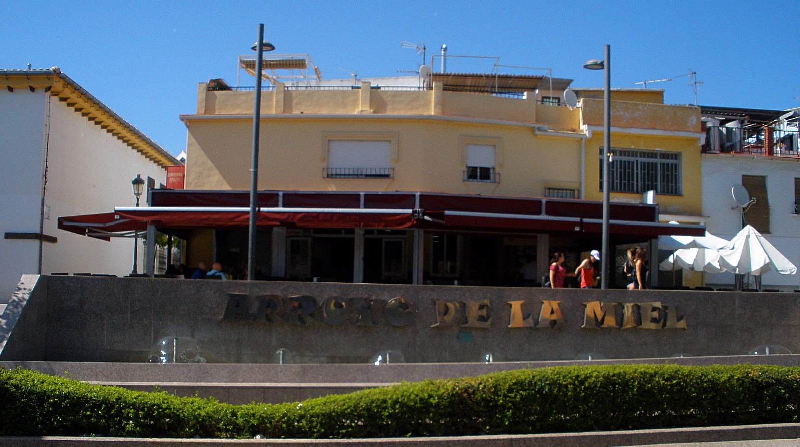 Las letras grandes de Arroyo de la Miel con una cafetería detrás