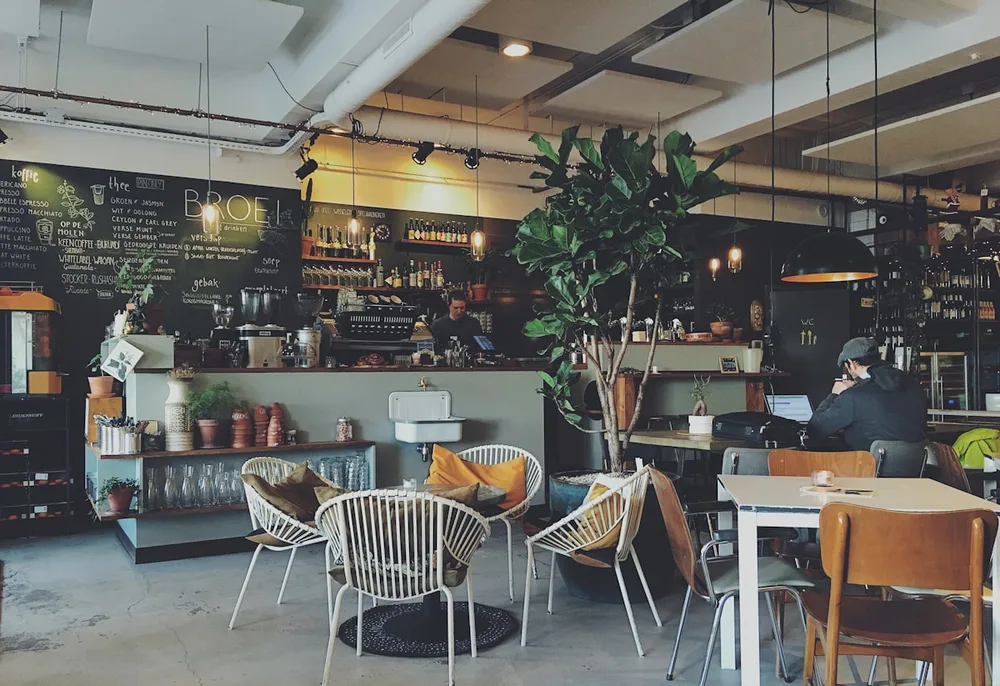 Cafetería con clientes usando el móvil